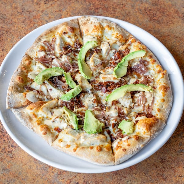Timothy's Lionville's American-style pizza, topped with chicken, caramelized onions, and avocado slices.