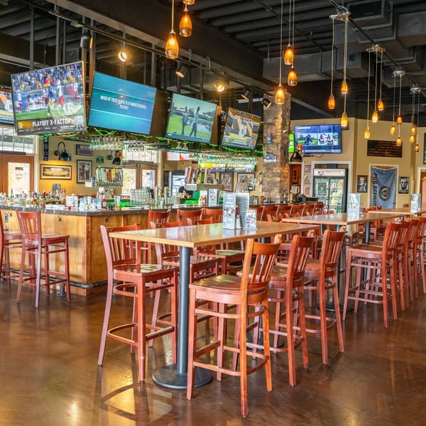 Timothy's Lionville interior with high-top tables, bar seating, and multiple TVs showing sports.